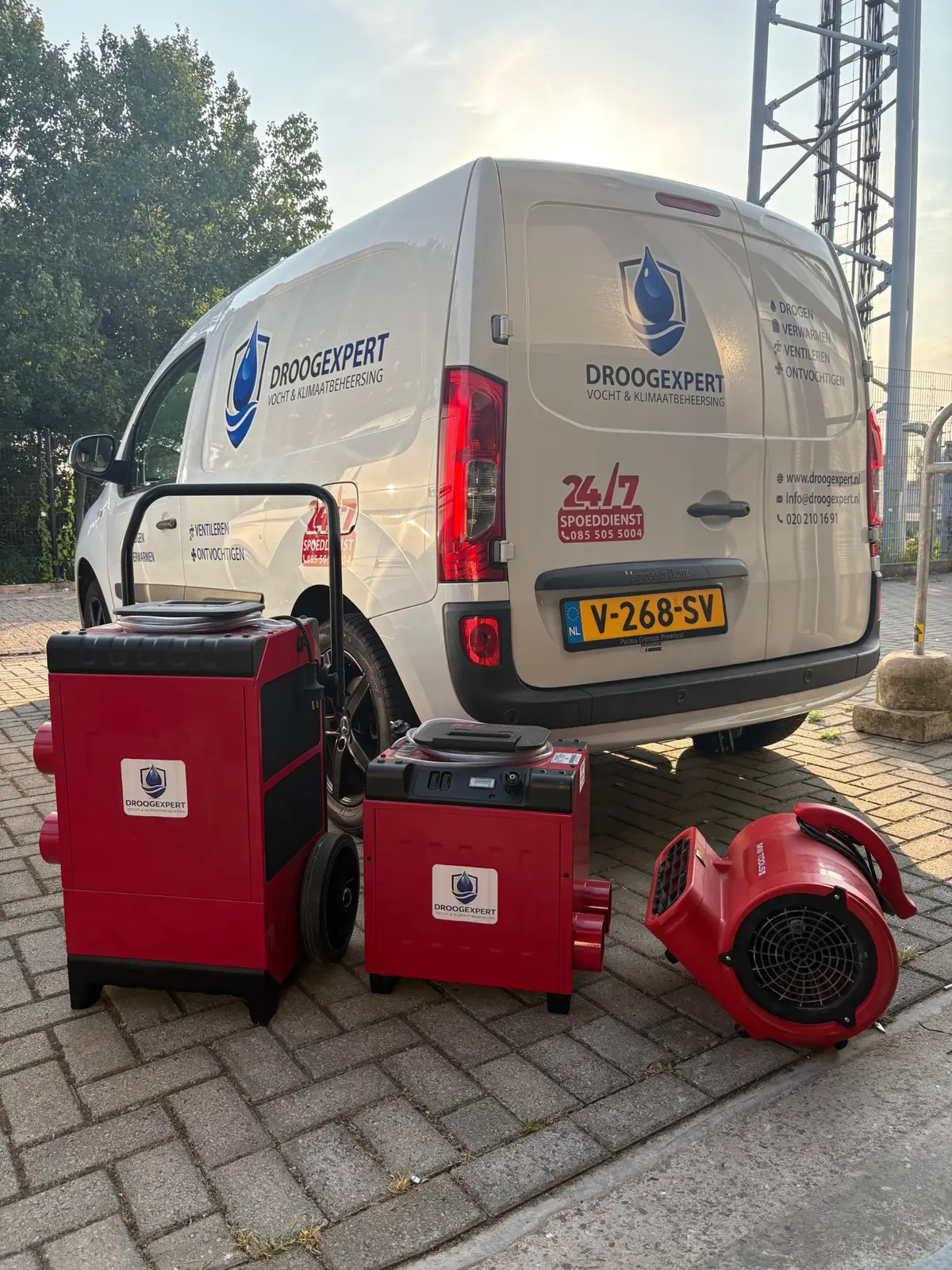 Droogexpert-servicewagen met professionele rode bouwdrogers en ventilator